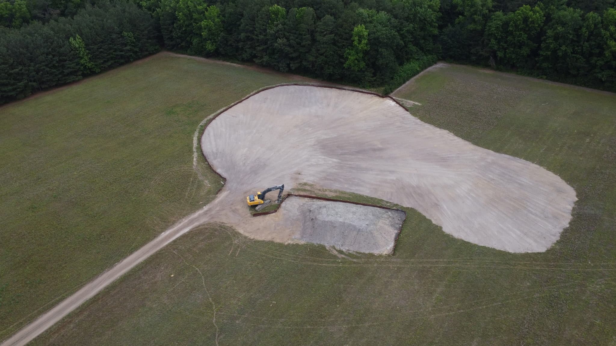 Aerial view of a low area of the agricultural field being raised with excavated material to return it to productive farmland.